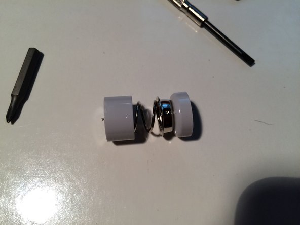 Image 2/3: Also, here is the battery terminal (spring loaded) which had to be forced out.  It's held in the tube by the expansion ring, which unfortunately is the best-made bit of this keyboard.  I forced it out using a long screw driver, but unfortunately broke the wires.  Keyboard had died anyway, thanks Apple.