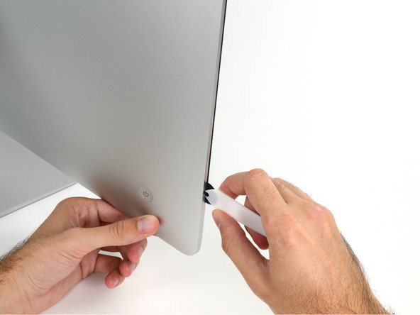 Image 2/2: The hub on the iMac Opening Tool will keep you from pushing the wheel in too far. If using a different tool, insert no more than 3/8" into the display. Otherwise, you risk severing antenna cables and causing serious damage.