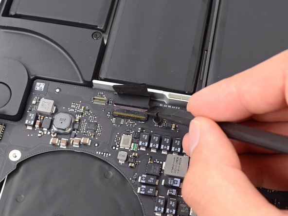Image 2/2: Use the flat end of a spudger to pull the keyboard ribbon cable out of its socket.