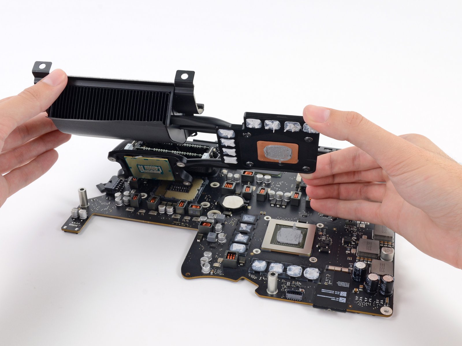 the iMac heatsink being lifted from the logic board. Image credit: iFixit