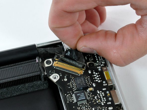 Image 2/2: When disconnecting the display data cable, do not pull on the black tab secured to the cable lock. We recommend wiggling the cable while applying tension to slowly "walk" the connector out of its socket.