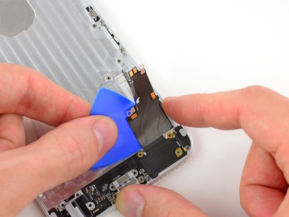 Image 3/3: Carefully work the pick down the right side of the Lightning connector and headphone jack cable, making sure to '''stop''' right as you hit the bottom.