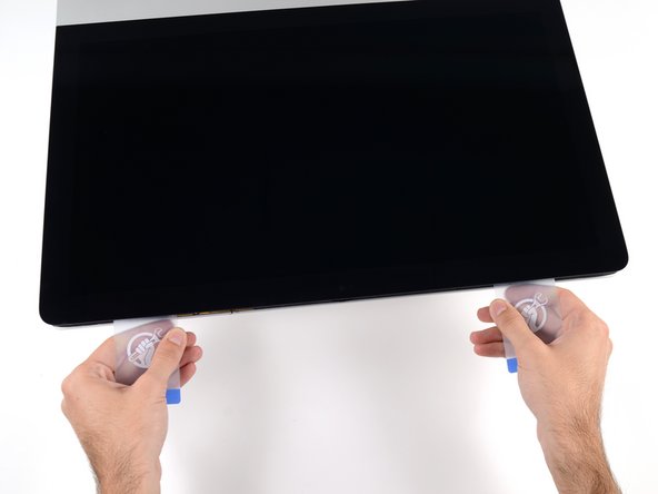 Image 2/3: Begin to lift the top of the display up from the frame.