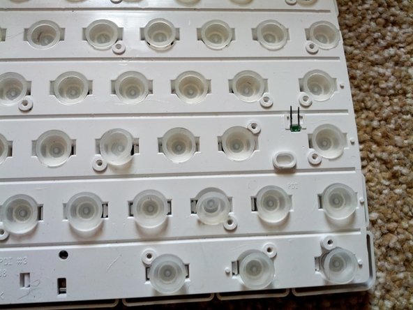 Image 1/3: Carefully bring the rest of the keyboard to the top of the white keyholder and fold the membrane over the top of the keys.