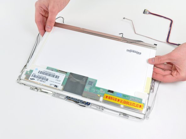 Lift up the LCD panel by its bottom edge and slide it out of the metal mounting brackets.