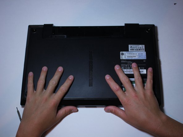 Put your hands on the back panel and use pressure to slide the panel down a few millimeters (as shown in the photo).