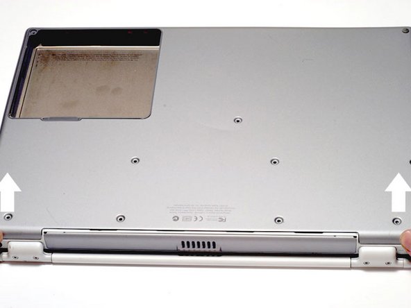 Image 1/1: The lower case may stick in the front on a tab just above the center of the DVD drive. Be careful as you work the case off, or you may break the thin strip of plastic just above the drive.