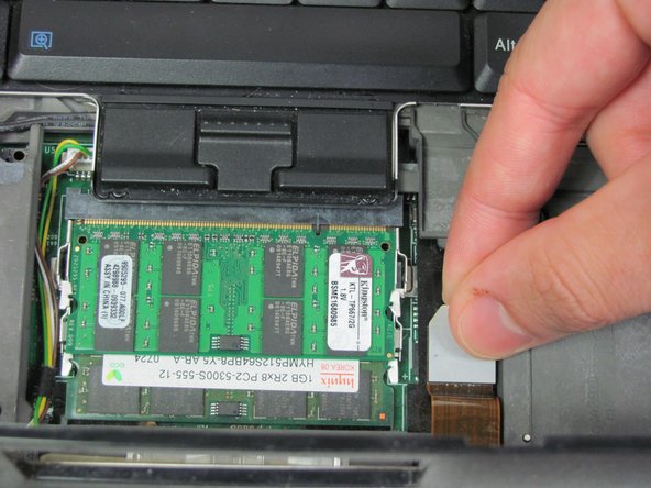 Image 2/2: Detach the connector by pulling upwards on the white tab.