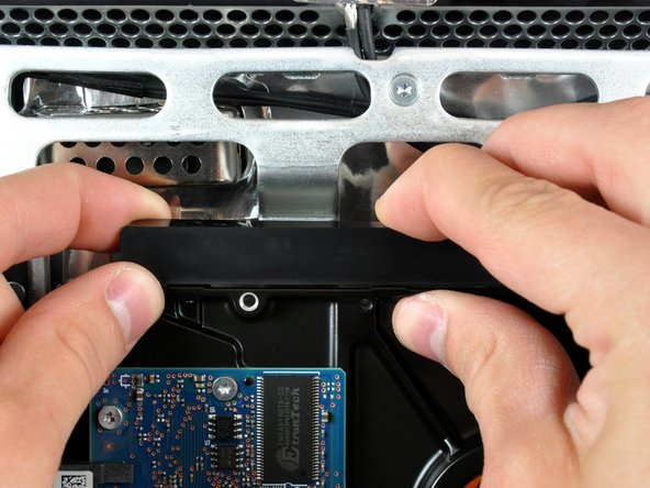 To remove the hard drive bracket, squeeze the middle against the side of the hard drive while rotating the top left edge toward yourself.