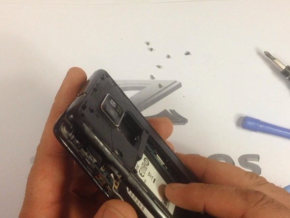 Use a plastic tool to remove the rear housing.