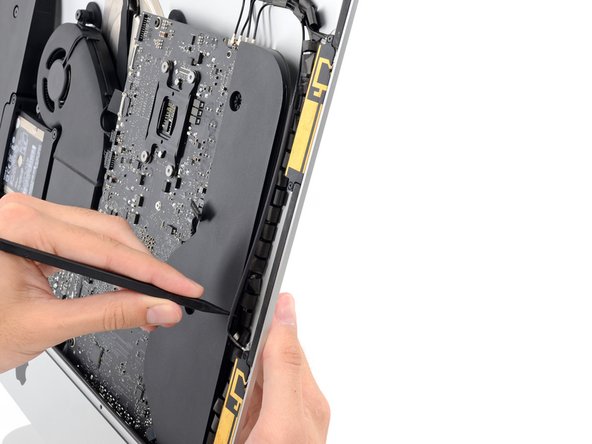 Image 3/3: Run the spudger down along the right side of the speaker to pry the antenna cable from its channel in the right speaker.