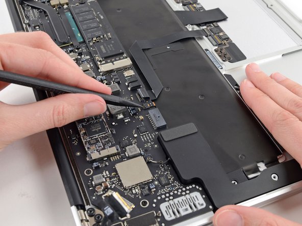 Image 2/3: Use your spudger to gently pull the keyboard backlight ribbon cable out of its socket.