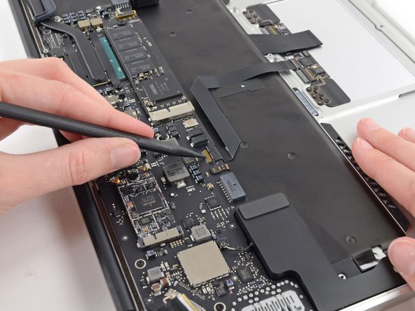 Image 2/2: Pull the trackpad ribbon cable straight out of its socket toward the front edge of the Air.