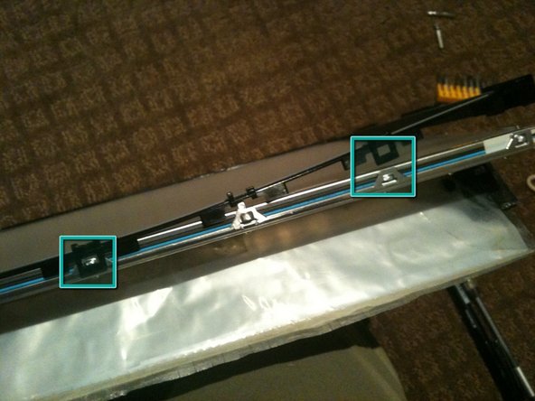 Image 1/3: Start by un-clipping the tabs along the top edge of the assembly.  There are 4 tabs along the top