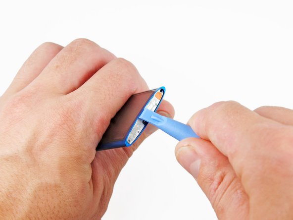 Image 1/1: While slightly lifting up on the iPod opening tool, pull the hold switch plate out of the iPod.