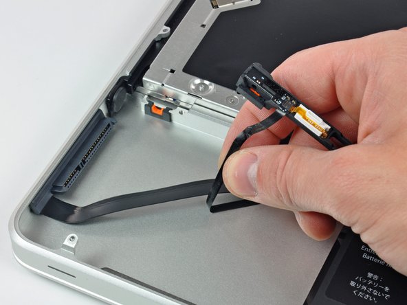 Image 2/2: Carefully peel the hard drive and IR sensor cable from the upper case.