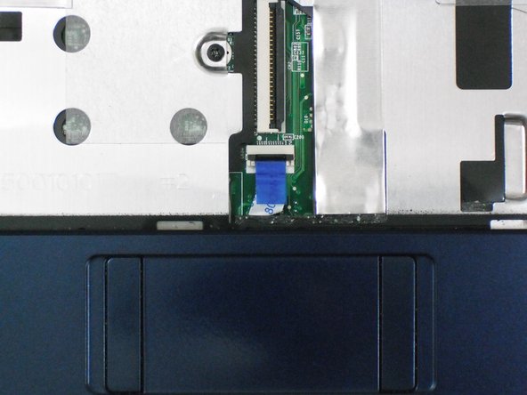 Flip up the retaining flap on the trackpad ribbon cable ZIF connector.