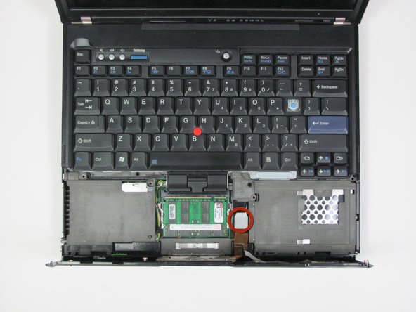 Image 1/2: The touchpad's data cable connects the palm rest to the base unit. BE CAREUL!