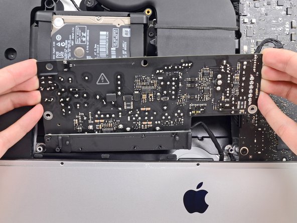 Image 3/3: '''Do not''' try to completely remove the power supply from the iMac yet—it is still connected to the logic board.