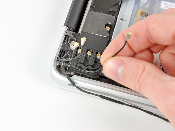 Image 3/3: De-route each of the cables from their channels in the AirPort/Bluetooth bracket.
