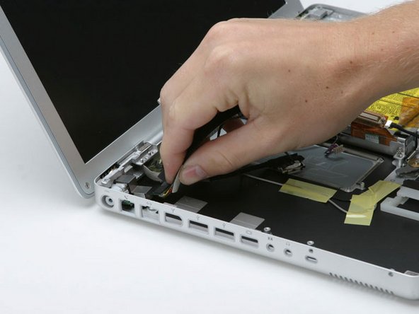 Image 1/1: Lift up the front right corner of the DC-In board and rotate it clockwise to slide the power receptacle out of the lower case.