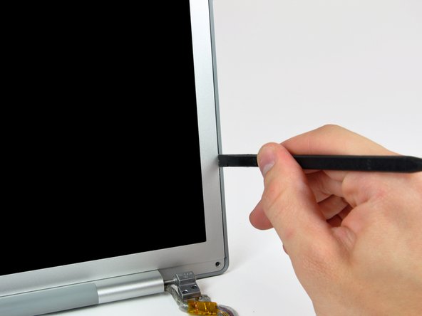 Image 1/3: Do not insert your spudger between the plastic strip and the rear bezel.