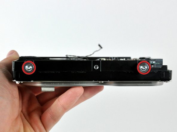 Remove the two T8 Torx screws and their attached rubber grommets from the hard drive.