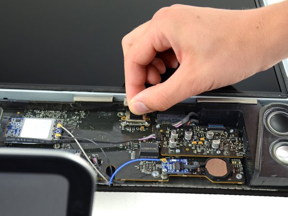 Firmly grasp the pull tab on top of the connector and pull it straight up out of its port.