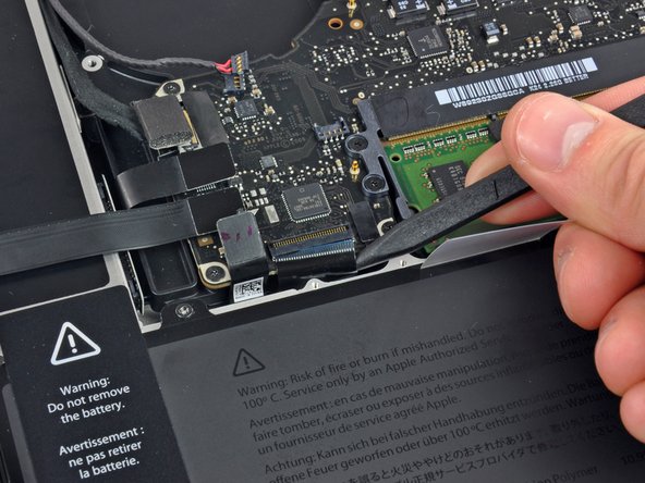 Image 3/3: Use your spudger to slide the keyboard ribbon cable out of its socket.