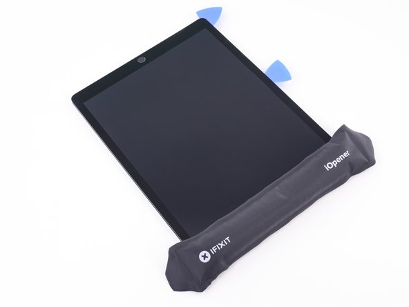 Reheat your iOpener and lay it over the top edge of the device. Wait a couple minutes for the adhesive to soften.