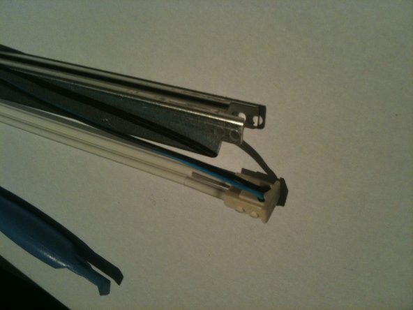 Image 3/3: Run the pry tool the length of the assembly and free the wires all the way to the other end cap