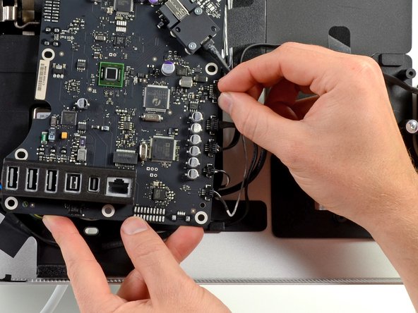 Image 1/3: A few T6 Torx screws are knocked out to remove the connector cover, and the Thunderbolt cable is disconnected.