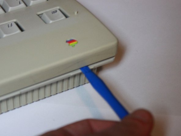 Image 3/3: Once unscrewed, flip over the keyboard and release the clips from the top. A plastic opening tool may be helpful, but they are fairly loose.