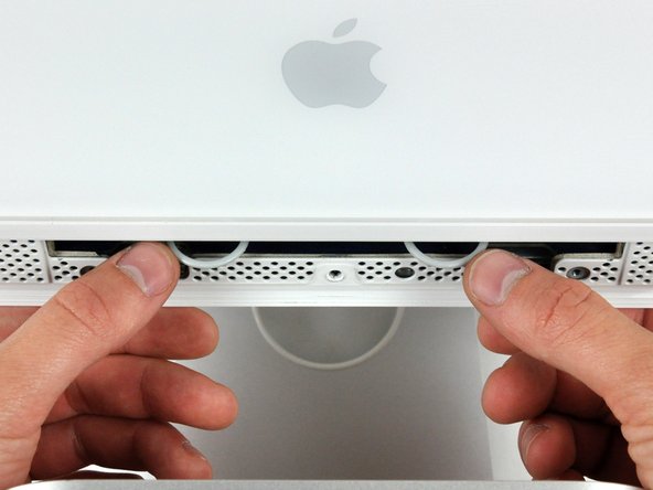 Image 1/2: Use your thumbs to press both RAM arms in past the front bezel for enough clearance to lift it off the rear case.