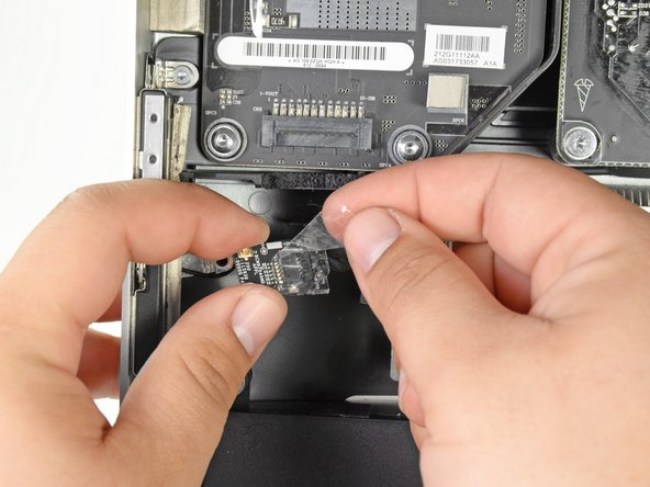 Image 2/3: Remove the tape wrapped around the Bluetooth board, being careful not to put to much tension on the still connected cable.