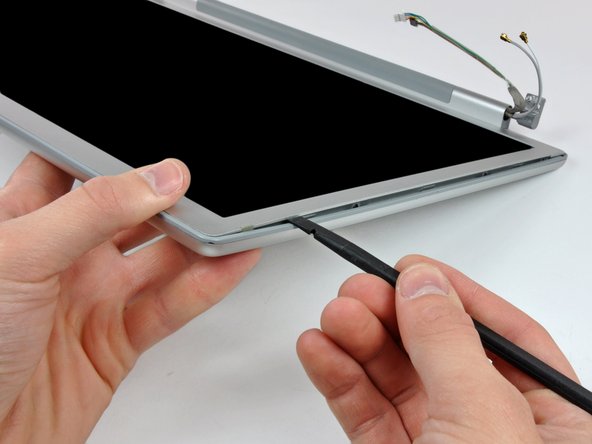 Image 3/3: Work along the left edge of the display until the rear bezel is evenly separated from the front bezel.