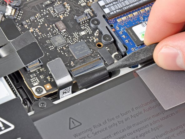 Image 3/3: Use the tip of a spudger to pull the keyboard ribbon cable out of its socket.