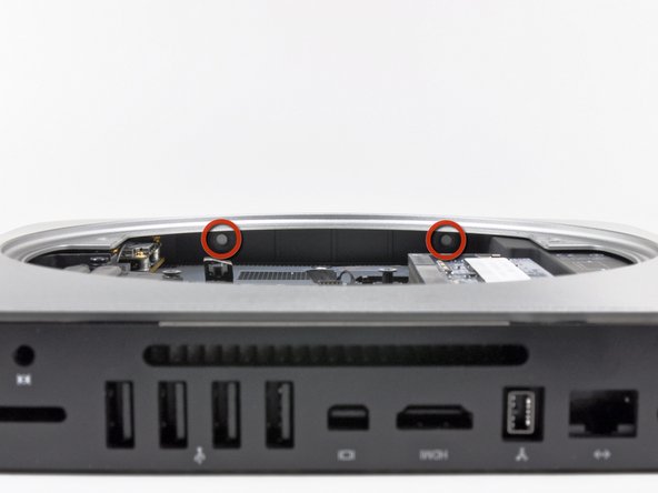 Image 2/2: When reinstalling the hard drive, be sure the two T8 Torx lugs on its far end are inserted into the two rubber grommets highlighted in red in the second picture before sliding the logic board back into place.