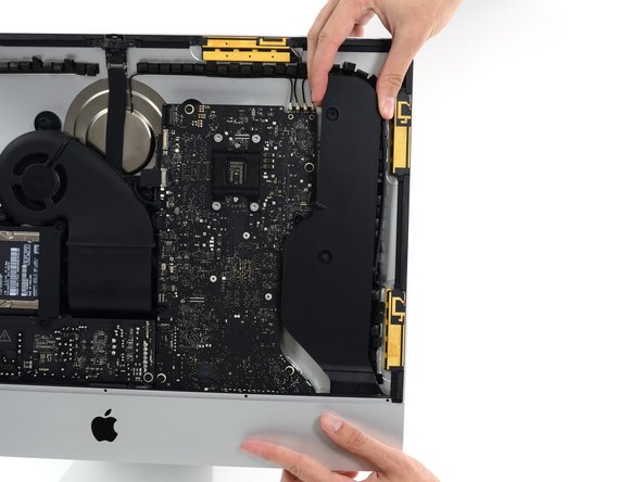 Image 2/3: Lift the right speaker straight up and remove it from the iMac. This may take some force, both hands and rocking the speaker right and left to get it out.