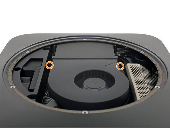 Two screws securing the fan to the logic board