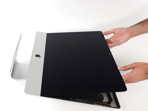 Image 1/2: At this point there is still a strip of adhesive along the bottom of the display, that will hold the display to the frame like a hinge. You can loosen this adhesive by working the display up and down a few times.