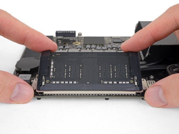 Two clips secure each RAM module in place, one on each side. Using your fingers, spread the clips away from the RAM module.