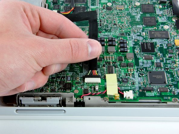 Image 2/2: Disconnect the DC-In cable from the logic board and angle the DC-In board out of its compartment.