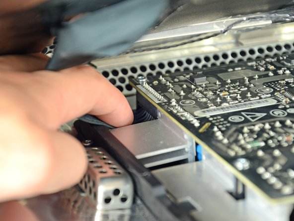 While still holding the display panel up, use two fingers to firmly push down on the power supply cable connector from its socket.