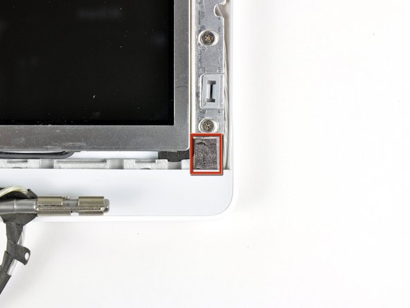 Remove the small piece of foam tape stuck down above each of the bezel covers.