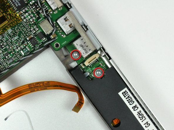 Image 1/2: Pull the board away from the side of the lower case to separate the USB socket from the bezel on the lower case.