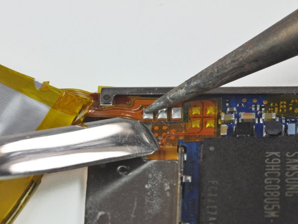 Image 1/2: '''DO NOT''' bridge the connection between the solder pads both on the board and on the ribbon cable with your spudger. Shorts have the potential to ruin the logic board.