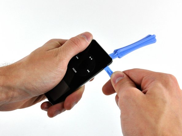 Insert a small iPod opening tool into the seam on the Hold button side of the iPod, with the edge of the tool pointing toward the rear panel.