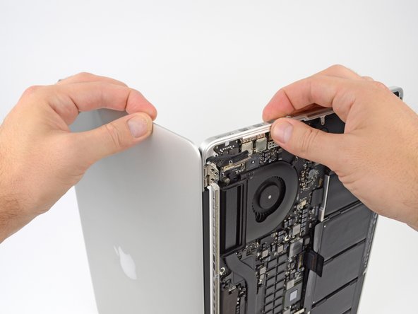 Image 1/3: Gently push forward on the bottom half of the device to detach it from the display assembly.