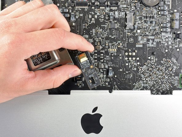 Image 2/2: Another leftover from the previous generation, the IR board, can simply be lifted straight up and removed from the iMac's front bezel.